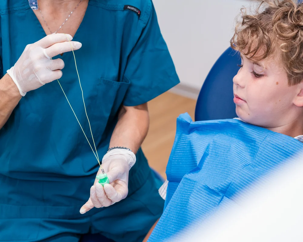 Bambino che guarda il dentista mentre spiega le terapie