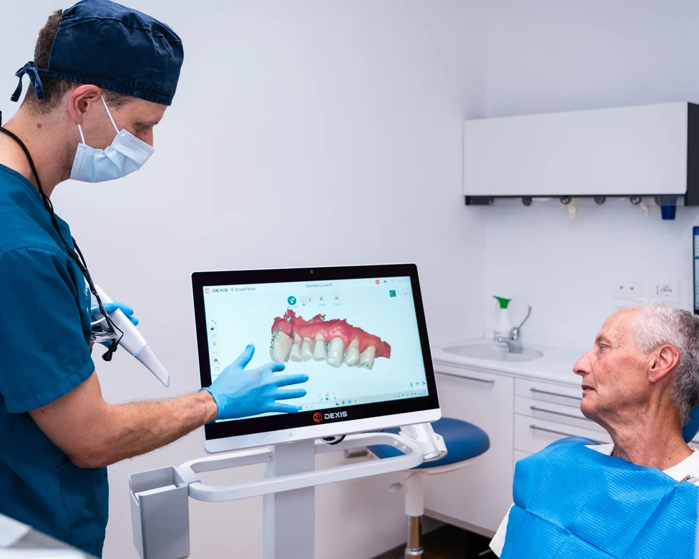 Dottore illustra sul monitor la dentiera